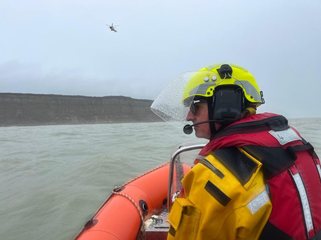 Rescue Boat and Helm looking towards Coastguard Helicopter